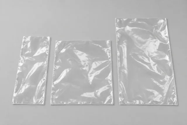 Drei unbedruckte flache Folienbeutel mit unterschiedlichen Breiten und Längen nebeneinander.